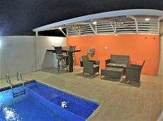 Dining table of four with TV, next to pool