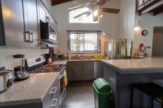 Newly remodeled kitchen with granite countertops, side by side refrigerator, dishwasher and gas stove