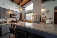 Newly remodeled kitchen with granite countertops, side by side refrigerator, dishwasher and gas stove