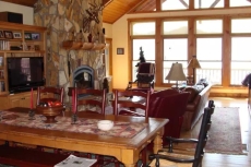 Another view of the great room which includes a large harvest table.  This room also contains a gas fireplace and large screen television.